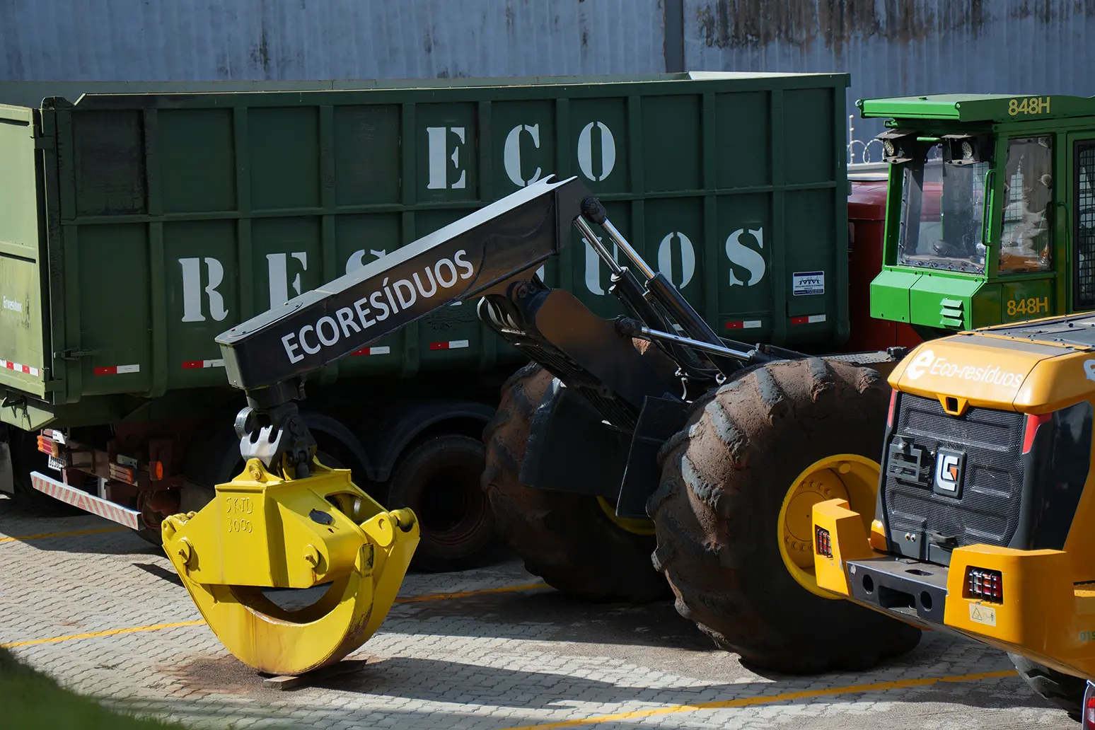 Tratores, garra hidráulica e caçamba da EcoResíduos utilizados na movimentação, no carregamento e no transporte de madeira e resíduos vegetais.